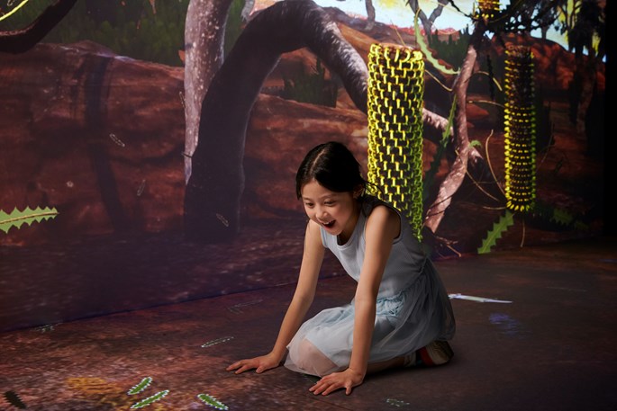 Une fille à quatre pattes dans un module de l'exposition