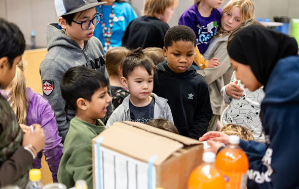 Un groupe d'enfants observent l'expérience de la fusée-bouteille.