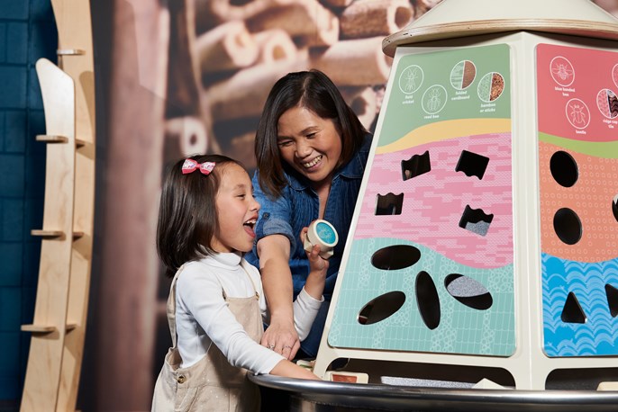 [A mother and child play in the Earth Matters exhibit.][Une adulte et une enfant jouent avec un des modules d'exposition.]