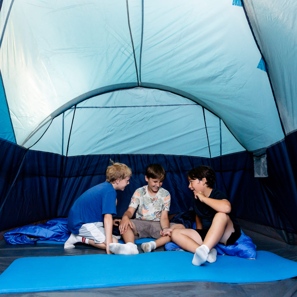 Un groupe de garçons jouant sous une tente de camping.